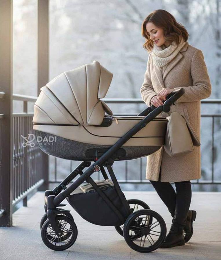 Kobieta w beżowym płaszczu spogląda na wózek dziecięcy z duża gondolą Camarelo Zeo z eko skóry na tle ośnieżonych drzew.